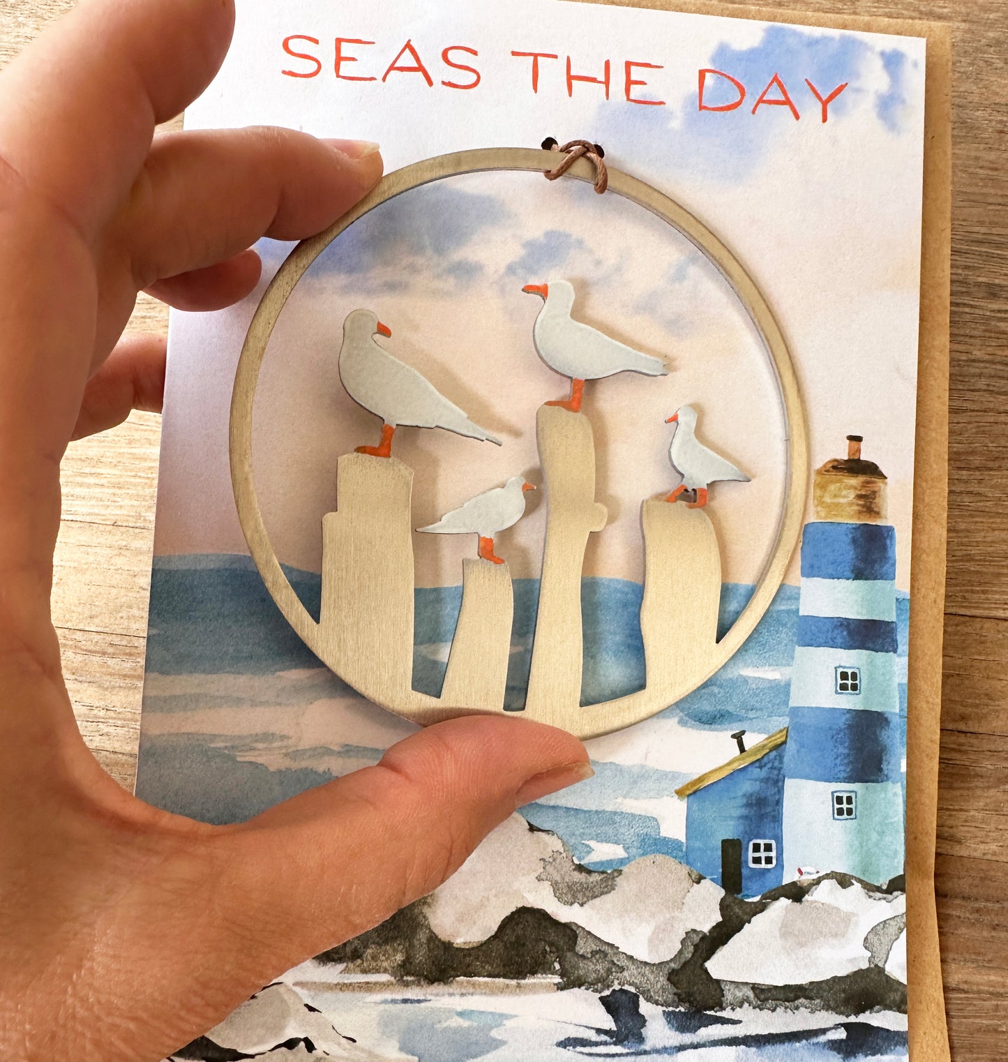 a hand holding a card with seagulls on it