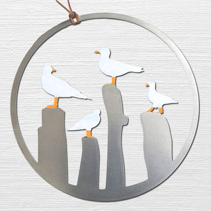 a metal ornament with three seagulls sitting on top of it