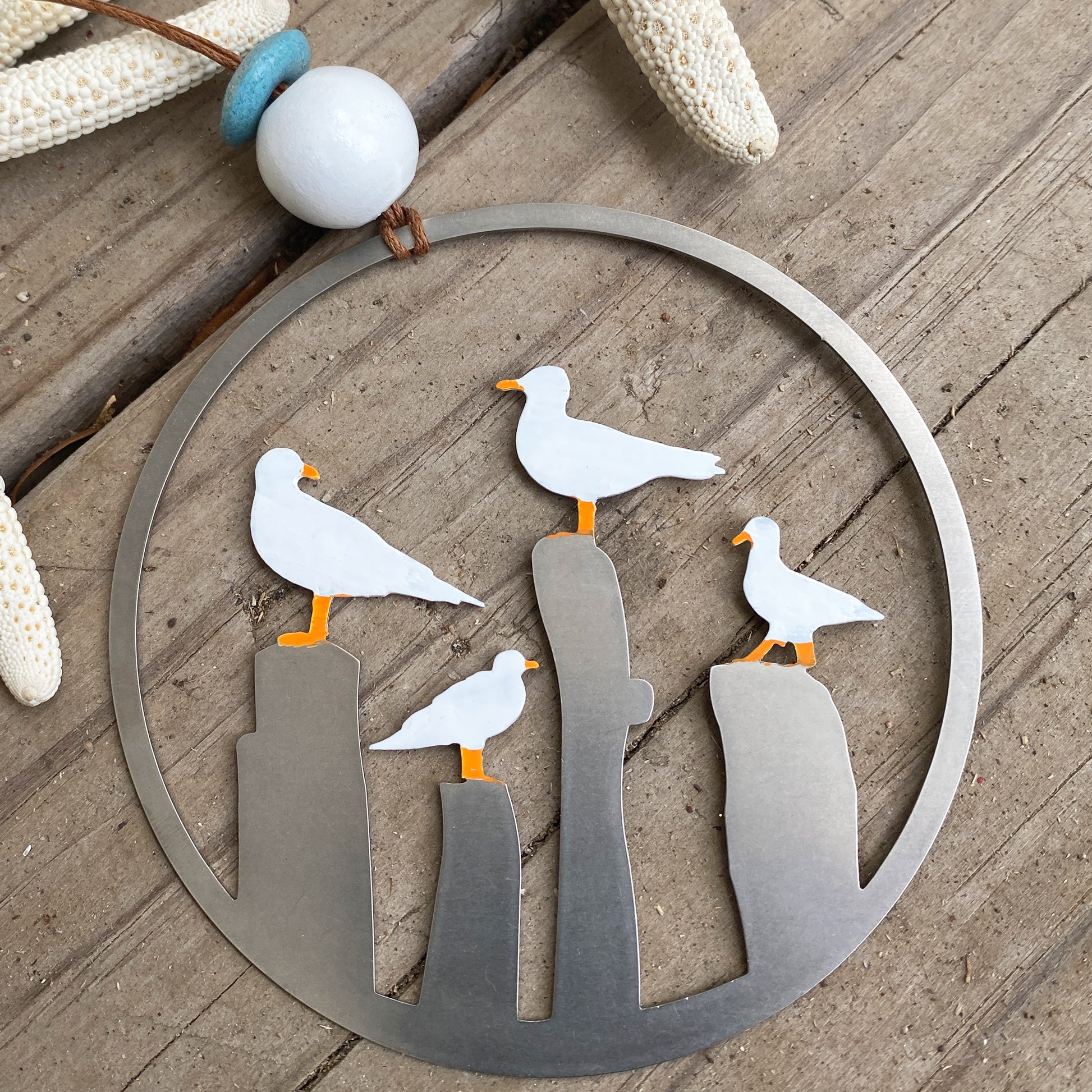 three seagulls are standing on a metal circle