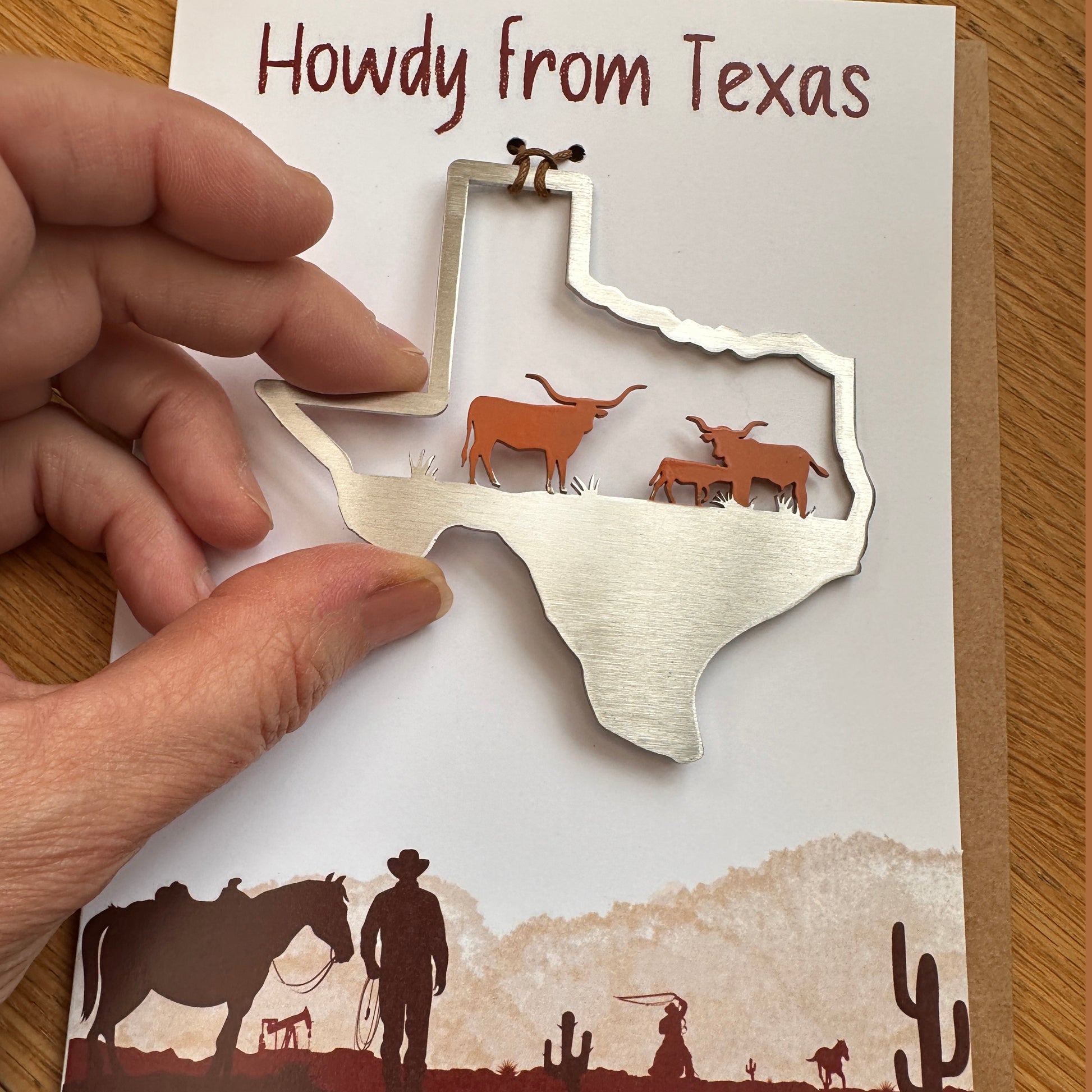 a person holding a key chain with a map of texas on it