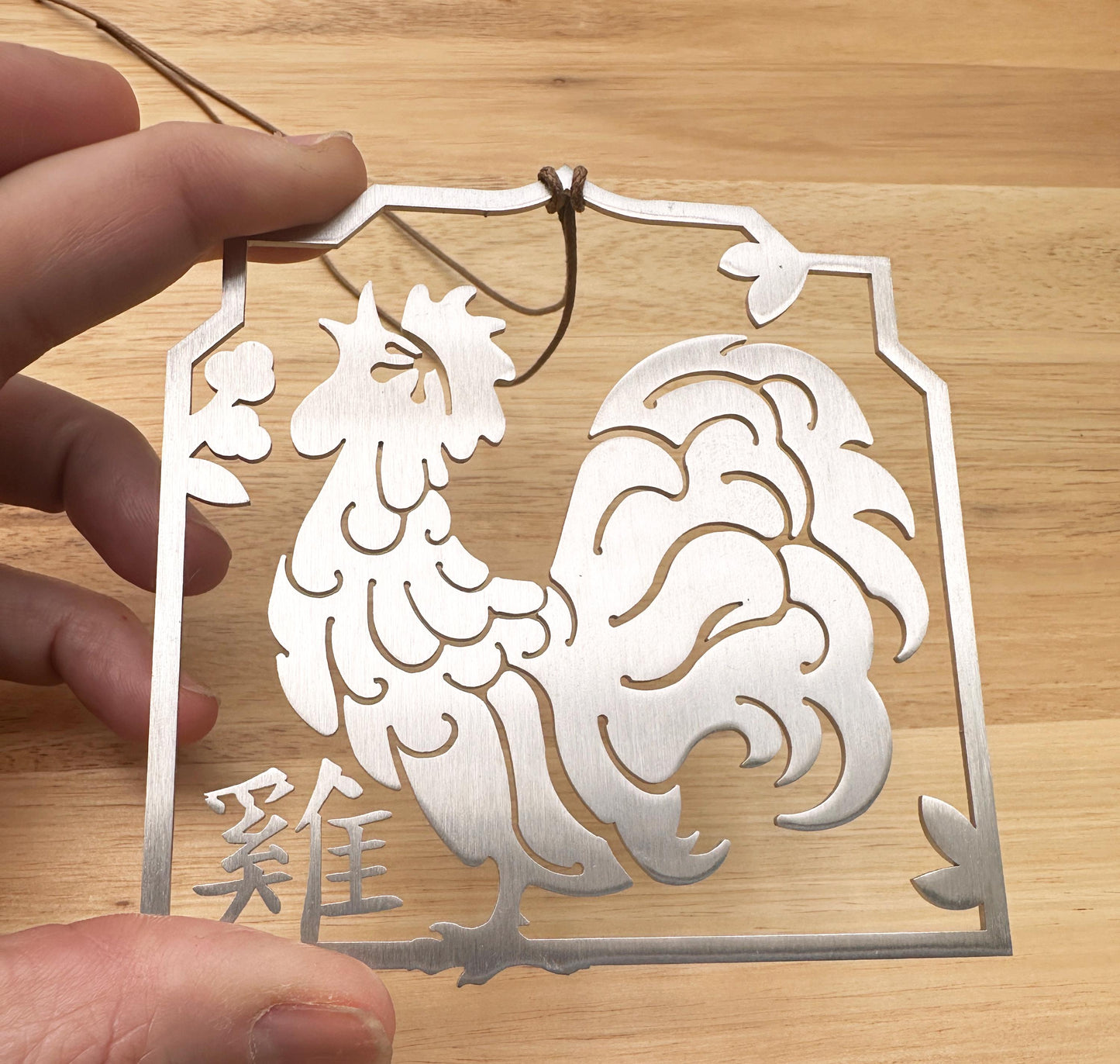 year of the rooster- Chinese Zodiac ornament made of stainless steel. Held in hand