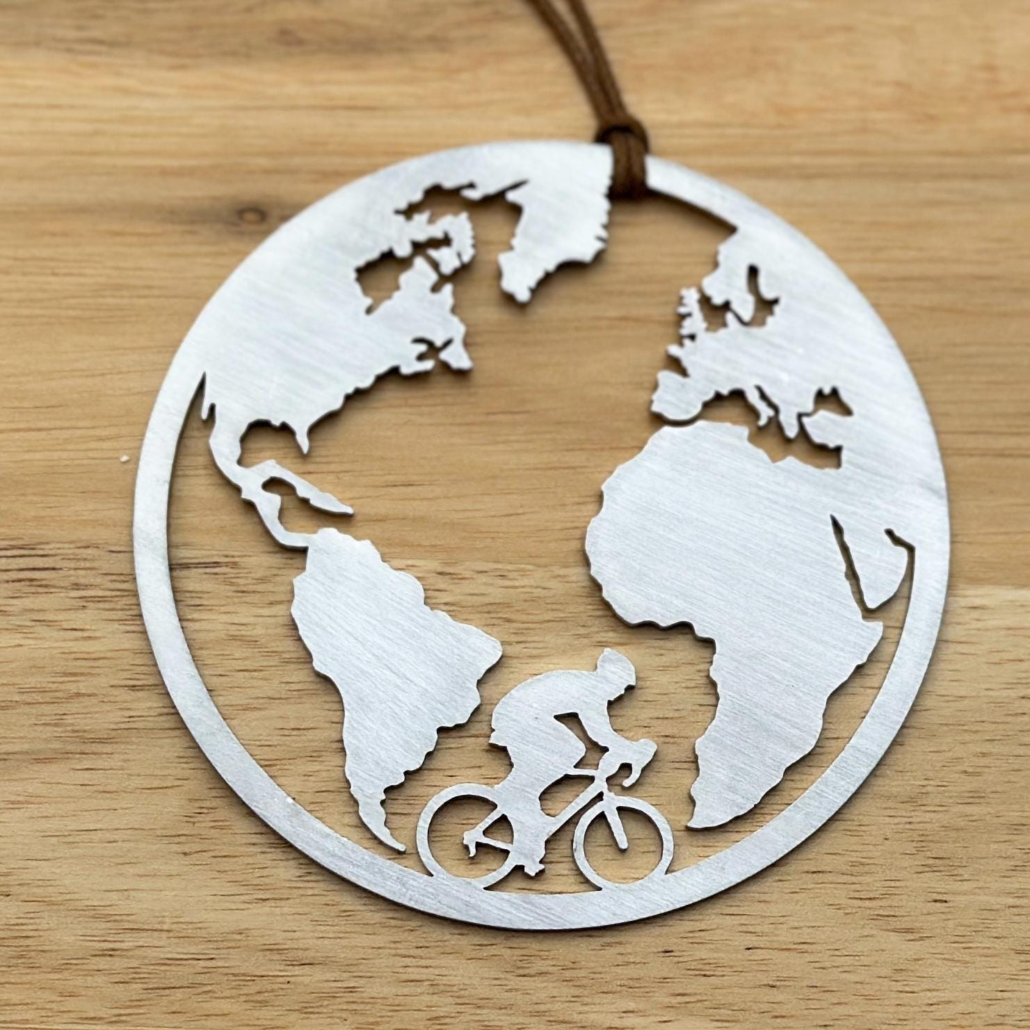 Mountain biker biking the world. Ornament made of stainless steel