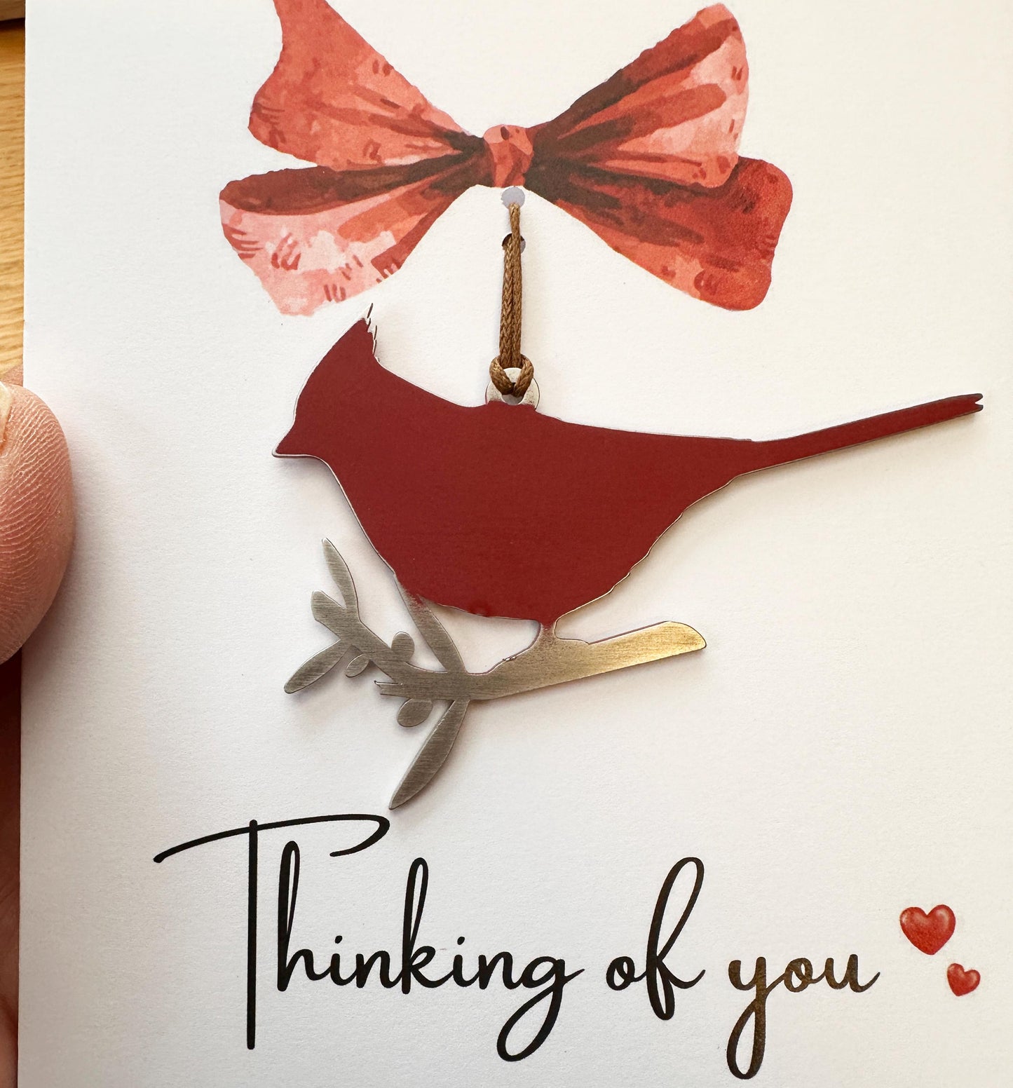 Red cardinal ornament on a greeting card entitled thinking of you